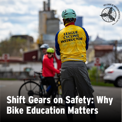 A man wearing a yellow shirt with text that says "League Cycling Instructor" faces away from the camera as he facilitates a League Cycling Instructor seminar.