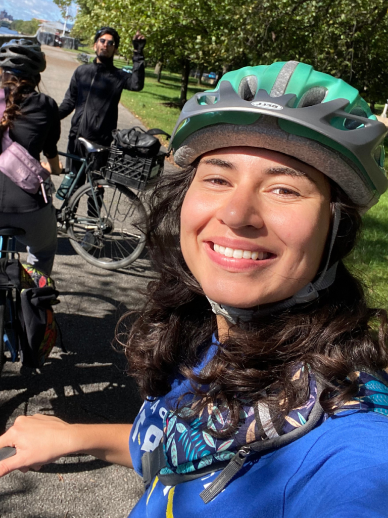 Lauren Newman smiles while wearing a green helmet on a group ride.