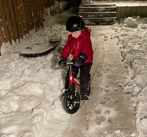 A young cyclist braves a frosty sidewalk