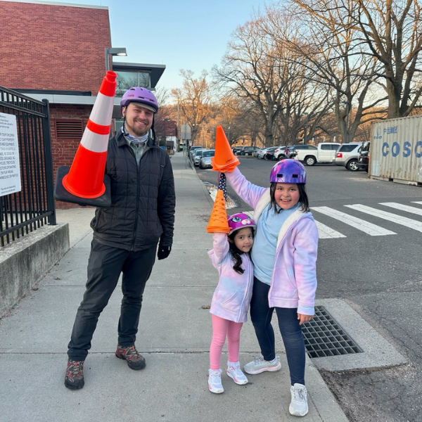 Elias Estabrook holding traffic cones with kids